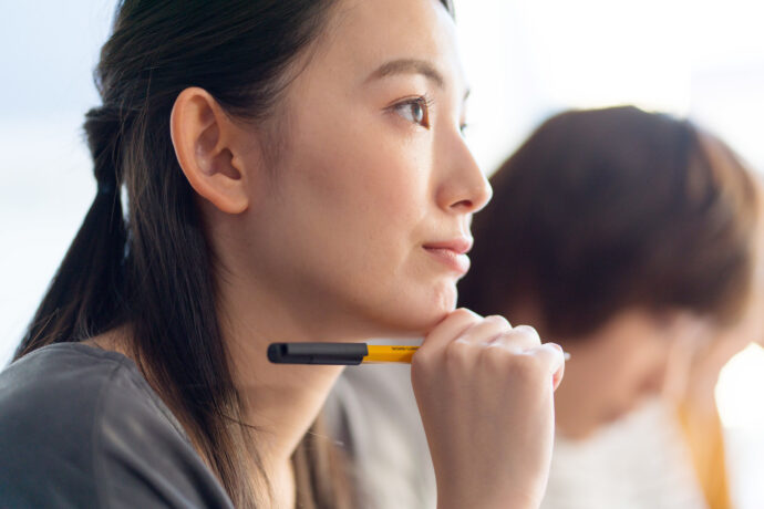 ノベルティとしてもらったボールペンを使う女子大学生