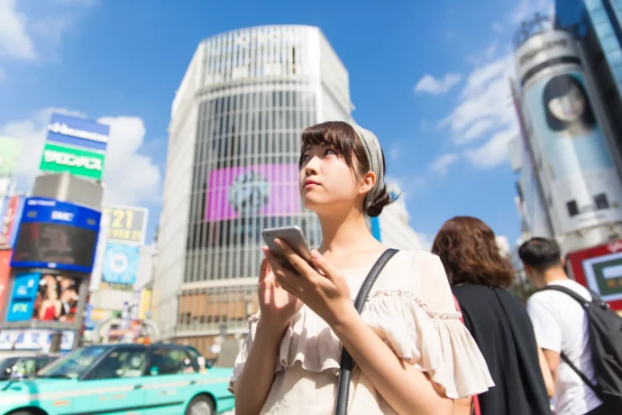 街中で屋外広告について調べている女子大生