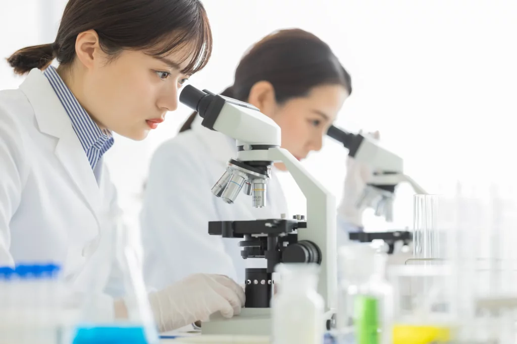 研究のため微生物を観察する大学生の女性