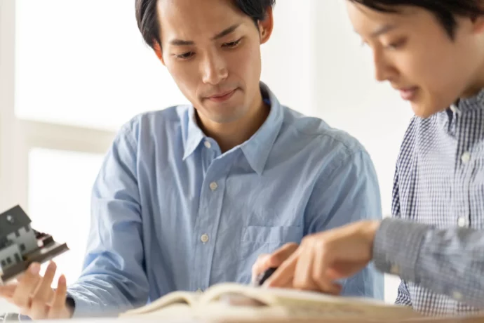 模型を手に建設について学ぶ大学生たち