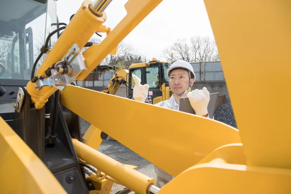 建機をメンテナンスするエンジニア