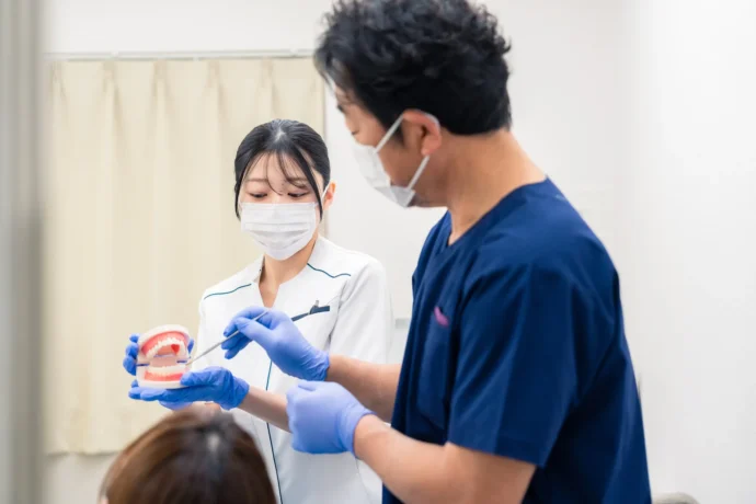 臨床実習中に指導を受けている女子歯学部生