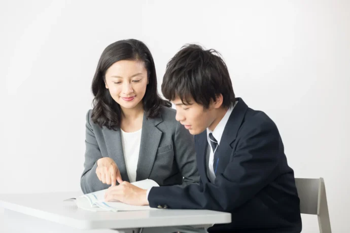 面接で聞かれる質問の対策をしている教師と生徒
